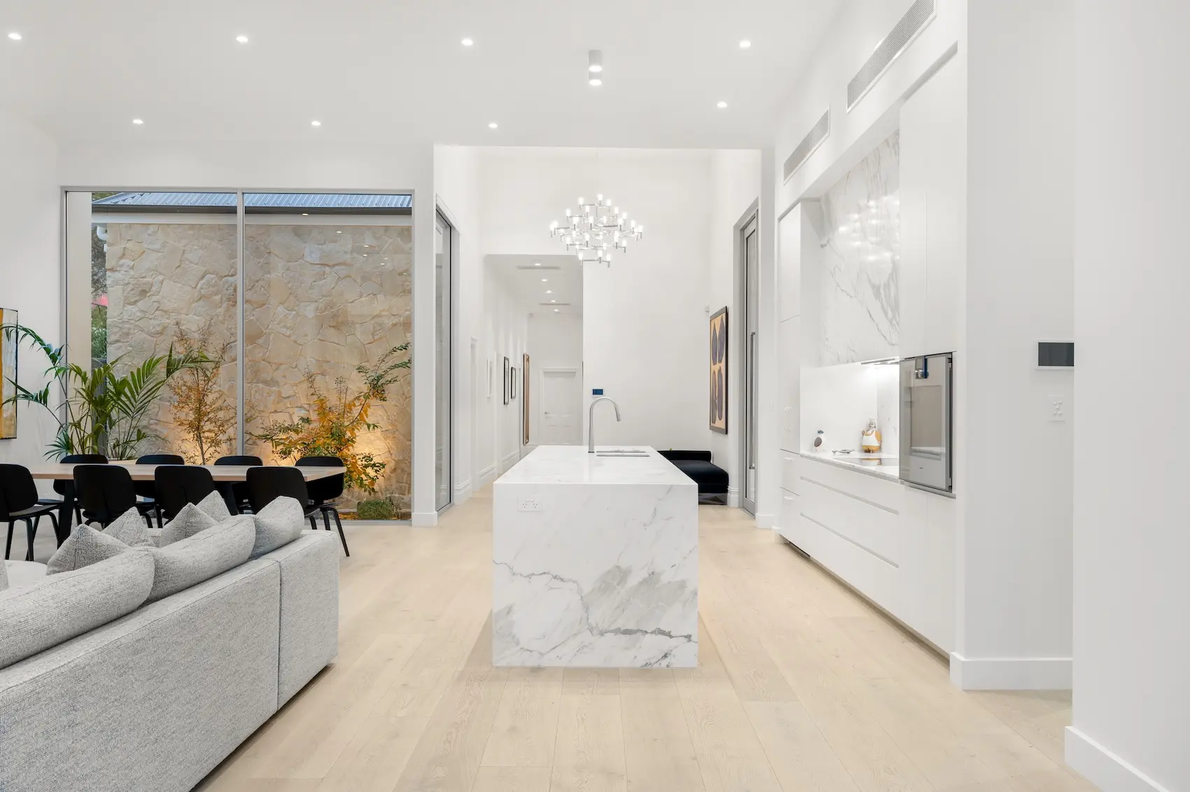 The kitchen of a residential property with a stone bench and dinning area.